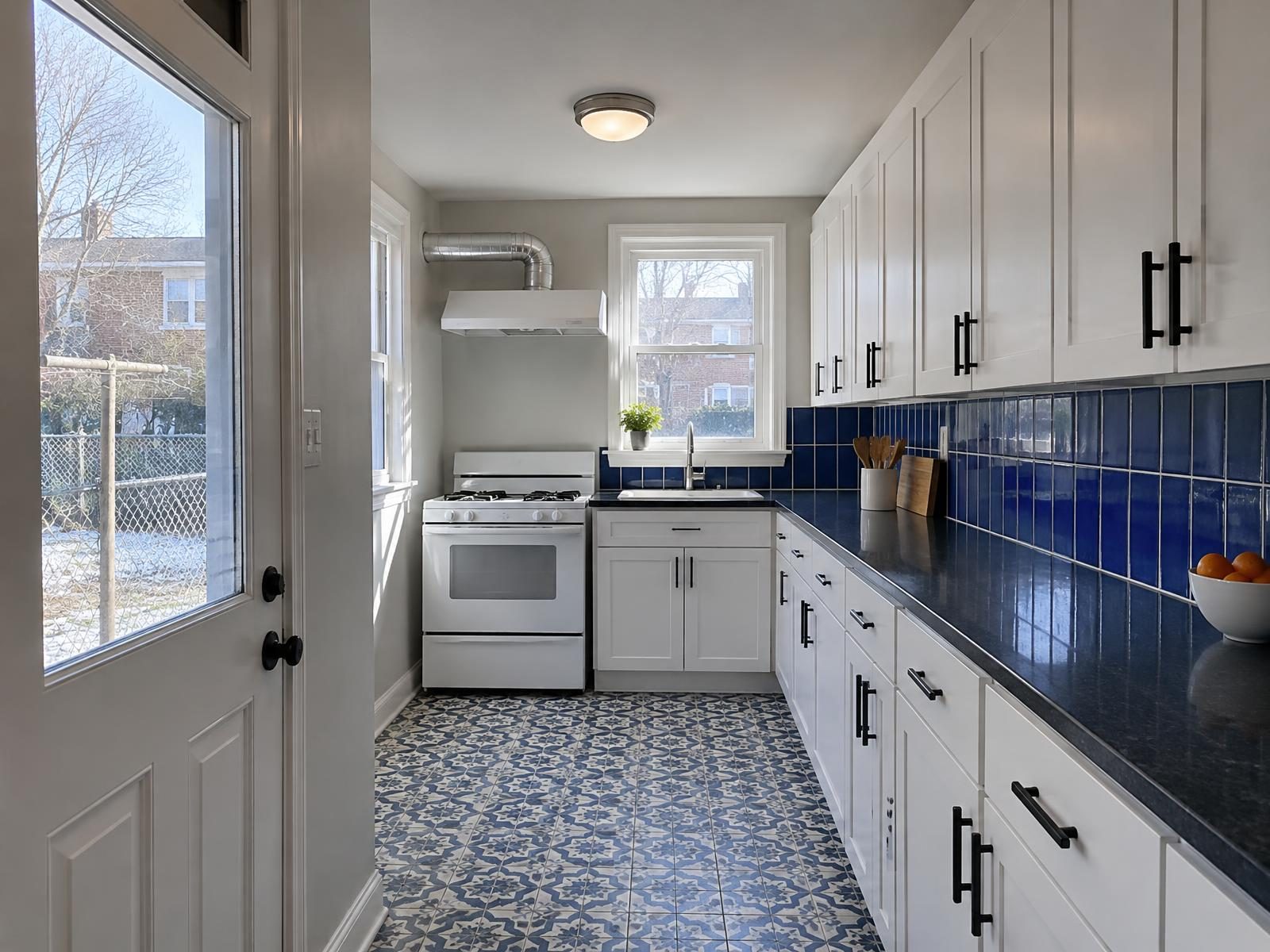 Illustration of a remodeled kitchen across the back of a 1950s brick end-of-group house in Essex, Baltimore County, with a side window over the sink, white cabinets along the shared wall and a range hood vented out the end wall.